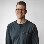 cam-krause A person with glasses and a gray shirt, who might be a talented home designer, smiles against a plain background.