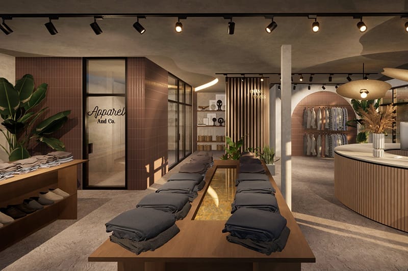 retail-tenant-improvement-rendering The clothing store interior features folded clothes on wooden tables, lush plants, and racks of hanging garments. With dim lighting and modern decor reminiscent of custom home design, the cozy atmosphere beckons shoppers to explore every corner.